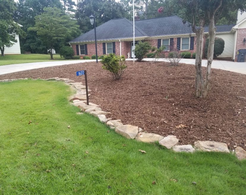Natural or cast stone is an alternative to treated wood when landscaping a bed.